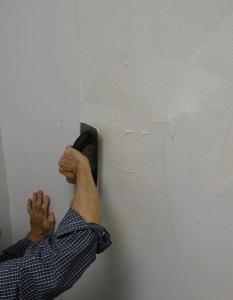 Using a trowel, apply vinyl tread adhesive to the wall, covering the whole area where the first panel is going. (You marked the wall right?)